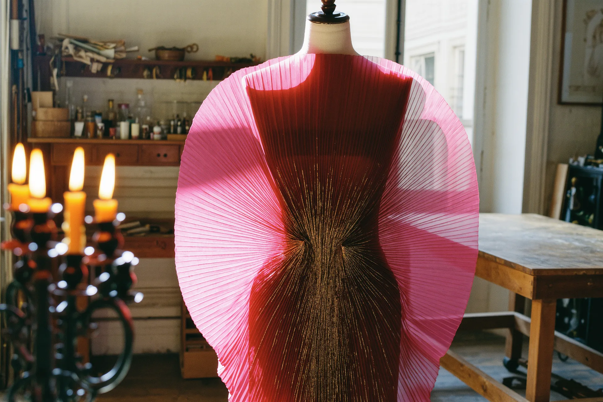Silhouette de haute couture drapée à la main dans un atelier parisien, lumière rasante